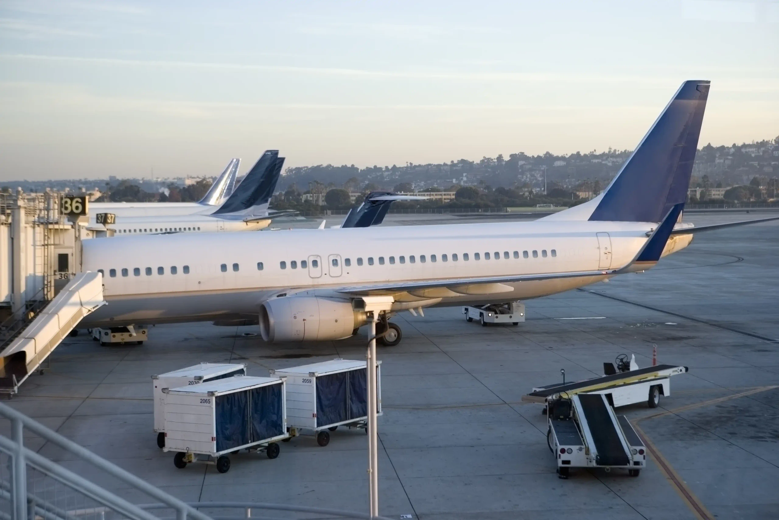 Commercial airline jet parked at an airport boarding gate, seen from an elevated side view